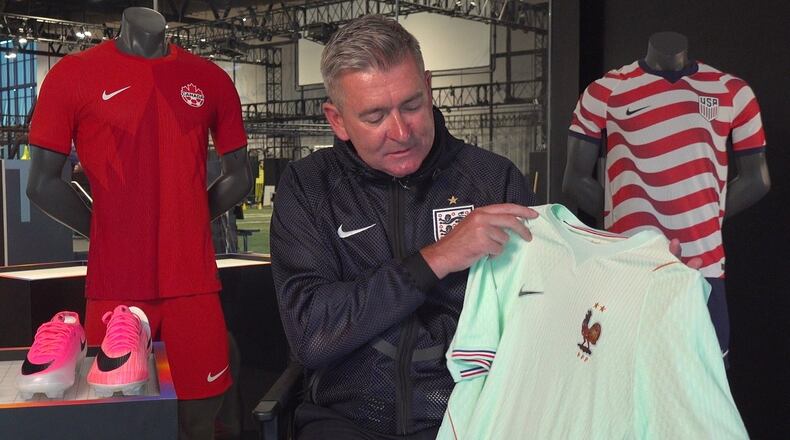 Phil McCartney, chief innovation, design and product officer for Nike, holds up the away jersey for France that the company designed for the World Cup during an interview at Nike headquarters in Beaverton, Ore., on June 22, 2026. (AP Photo/Claire Rush)