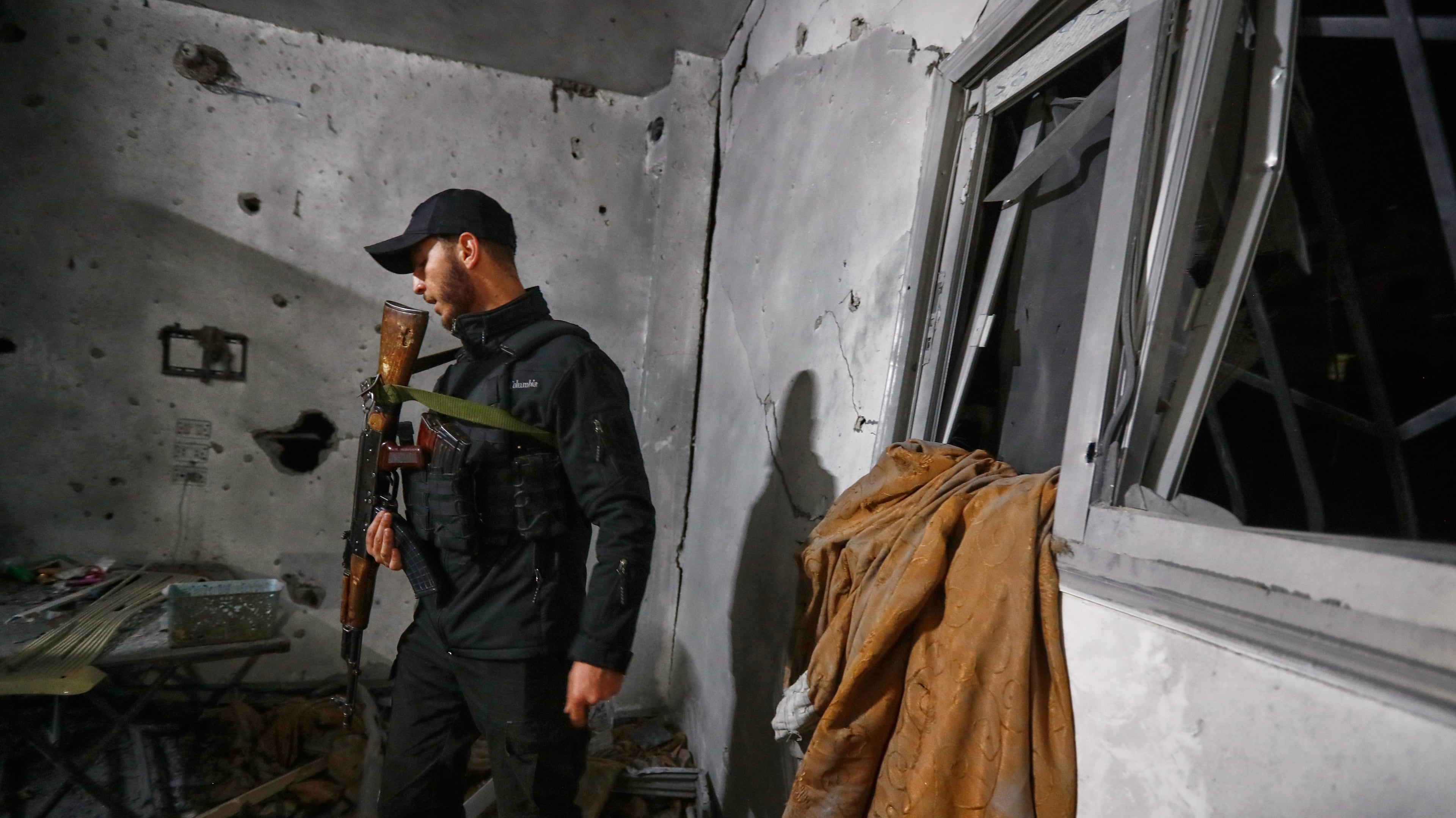 A Syrian Internal Security Forces officer inspects a home in Damascus, Syria, Friday, Nov. 14, 2025, after it was hit by rockets, according to state media. It was not immediately clear who was behind the attack. (AP Photo/Omar Sanadiki)