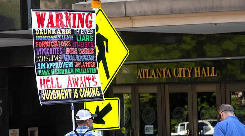 Kerrigan Skelly holds a protest sign outside Atlanta City Hall before Steven Igarashi-Ball, who performs drag as Miss Terra Cotta Sugarbaker, reads to a group of children at the Drag Queen Story Hour event at Atlanta City Hall on Saturday, June 29, 2019. Skelly has joined preachers who've spoken on some of Georgia's college campuses. (Steve Schaefer / AJC file photo)