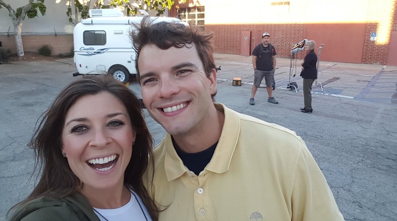 Lindsey Nubern (left) takes a selfie with her husband, Adam Nubern, outside the little white camper they were considering, during a break in filming for an episode of HGTV’s “Tiny House Hunters.” The episode with the Nuberns, both University of Georgia graduates, will air again on May 2. CONTRIBUTED PHOTO