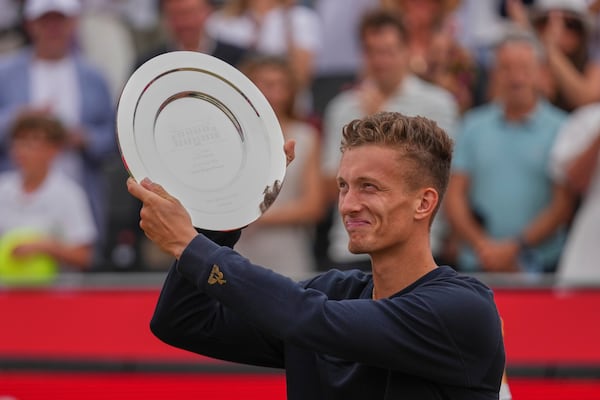 Jiri Lehecka of the Czech Republic hold up the runners-up plate after being defeated by Carlos Alcaraz of Spain in the men's singles final of the Queens Club tennis championships in London, Sunday, June 22, 2025. (AP Photo/Joanna Chan)