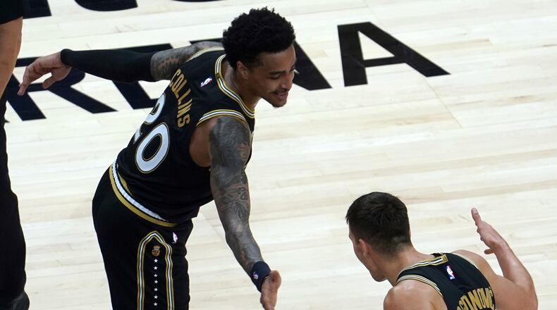 Atlanta Hawks forward John Collins (20) celebrates with teammate Bogdan Bogdanovic (13) after their win in an NBA basketball game against the Miami Heat, Friday, April 23, 2021, in Atlanta. (AP Photo/Tami Chappel)