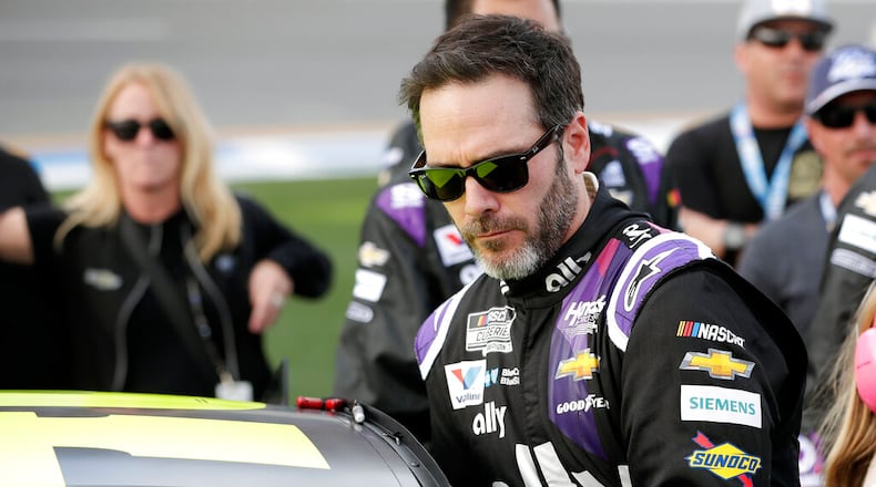 FILE - In this Feb. 16, 2020 file photo Jimmie Johnson climbs intp his car before the NASCAR Daytona 500 auto race at Daytona International Speedway in Daytona Beach, Fla. NASCAR seven-time champion Jimmie Johnson tested positive for COVID-19 and will not compete in Sunday’s race in Indianapolis. (AP Photo/John Raoux, File)