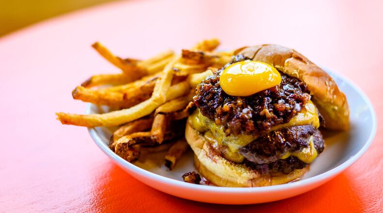The Big Day Burger at Field Day is a double stack with some extras: jammy-sweet bacon agrodolce and a perfect confit egg yolk. CONTRIBUTED BY HENRI HOLLIS