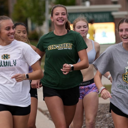 Cross country runner Madison DeCleene, center, runs with her St. Norbert College teammates, Friday, Oct. 17, 2025, in De Pere, Wis. (AP Photo/Morry Gash)