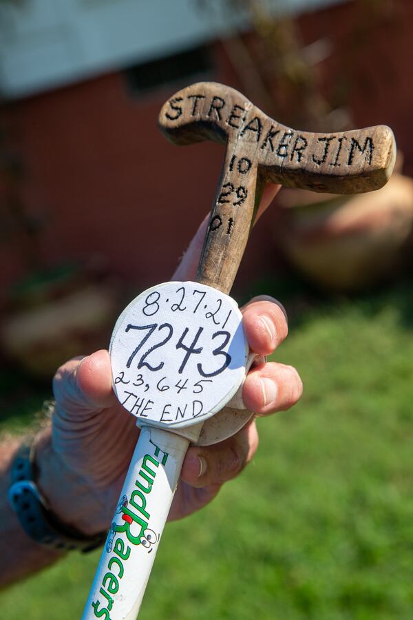 Jim Merritt, 73, of Buford, holds the what stick he took with him on his runs. It commemorates his 7,243-day running streak. PHIL SKINNER FOR THE ATLANTA JOURNAL-CONSTITUTION.