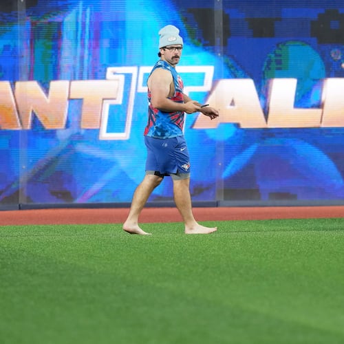 Toronto Blue Jays outfielder Davis Schneider walks barefooted in the outfield during World Series baseball workouts, Thursday, Oct. 30, 2025, in Toronto. (Nathan Denette/The Canadian Press via AP)