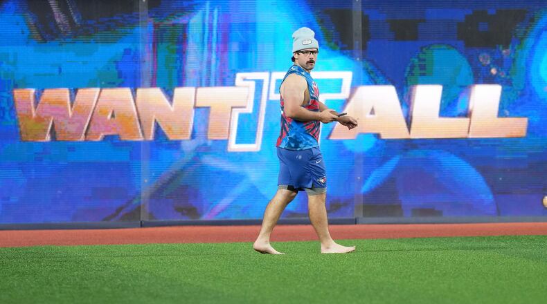 Toronto Blue Jays outfielder Davis Schneider walks barefooted in the outfield during World Series baseball workouts, Thursday, Oct. 30, 2025, in Toronto. (Nathan Denette/The Canadian Press via AP)