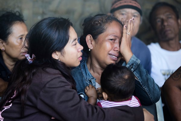 A relative of a passenger weeps after a ferry sank while en route to the resort island of Bali, in the waters off Banyuwangi, East Java, in Gilimanuk, Bali island, Indonesia, Thursday, July 3, 2025. (AP Photo/Firdia Lisnawati)