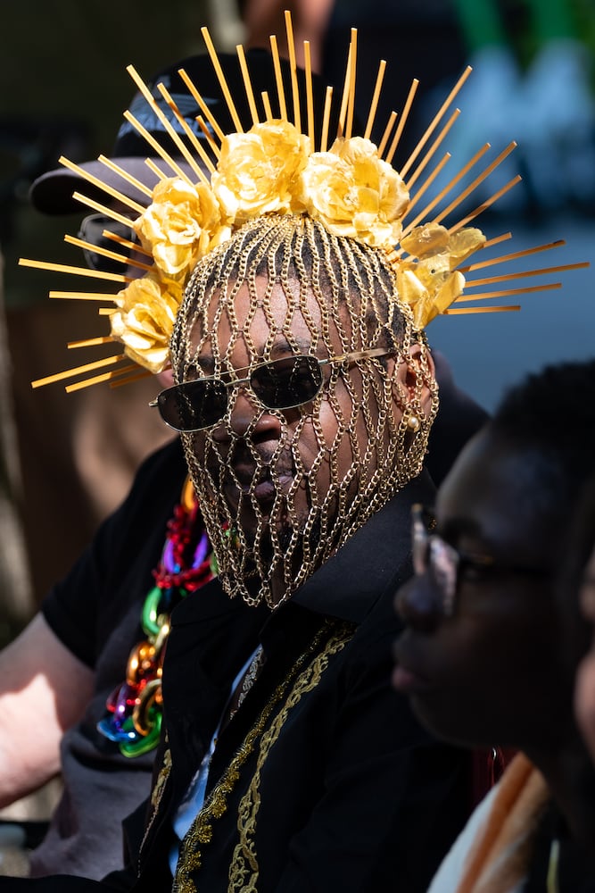 Antwan Davidson watches the Atlanta Pride Parade from behind a beaded head covering Sunday, Oct. 12, 2025. (Ben Gray for the AJC)