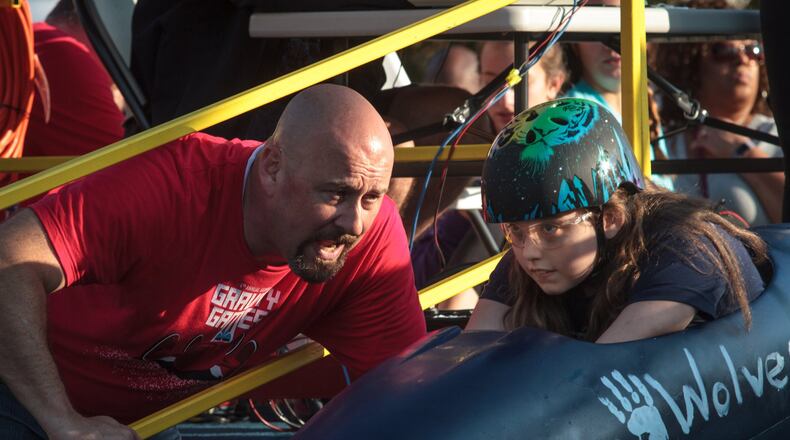 Race official Russell Bonds gives Meggen Greene last-minute instructions before she starts her trial run during the Gravity Games on Saturday, Nov. 4 in downtown Douglasville. The event is a gravity-only car race competition presented by Google, Georgia Tech and the city of Douglasville. STEVE SCHAEFER / SPECIAL TO THE AJC