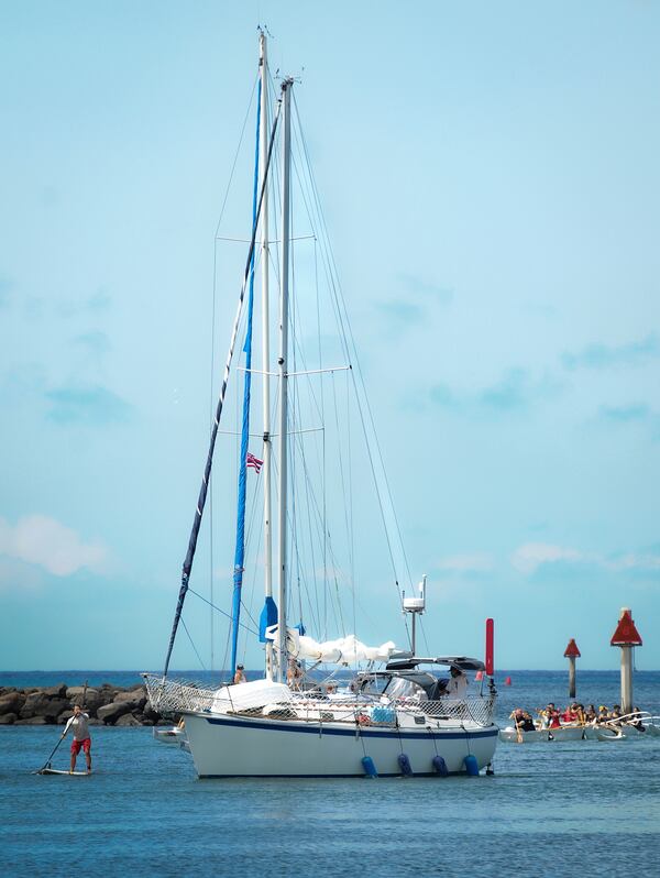 Oliver Widger, (back of boat) a 29-year-old Oregon man who sailed from Oregon to Hawaii, arrives at the Waikiki Yacht Club, on Saturday, May 24, 2025 in Waikiki, Hawaii. (AP Photo/Michelle Bir)