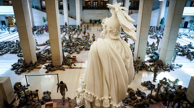 Members of the National Guard rest in the Capitol during a break in shifts. No Georgia National Guard troops slept in the parking garage overnight, Gov. Brian Kemp said Friday. (Erin Schaff/The New York Times)