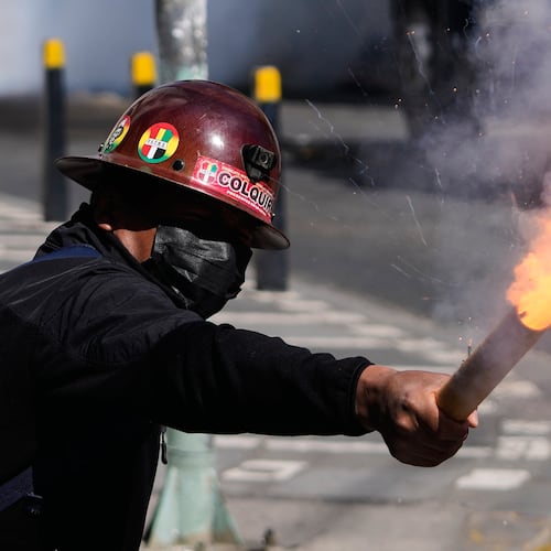 A miner launches a firecracker at police during an anti-government protest in La Paz, Bolivia, Monday, May 18, 2026. (AP Photo/Juan Karita)