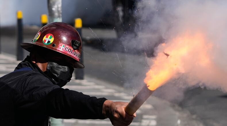 A miner launches a firecracker at police during an anti-government protest in La Paz, Bolivia, Monday, May 18, 2026. (AP Photo/Juan Karita)