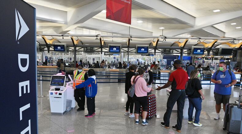 Delta Air Lines employees assist customers in the Domestic Terminal at Hartsfield-Jackson Atlanta International Airport in Atlanta on Tuesday, October 5, 2021. (Hyosub Shin / Hyosub.Shin@ajc.com)