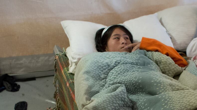 A Central American girl lies down to get some rest at a center that provides assistance to newly arrived migrant families with children in McAllen, Texas. (AP Photo / Rebecca Blackwell)