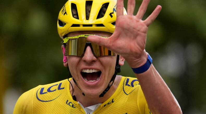 Slovenia's Tadej Pogacar, wearing the overall leader's yellow jersey, celebrates as he crosses the finish line of the last stage of the Tour de France cycling race with start and finish in Paris, Sunday, July 26, 2026. (AP Photo/Mosa'ab Elshamy)