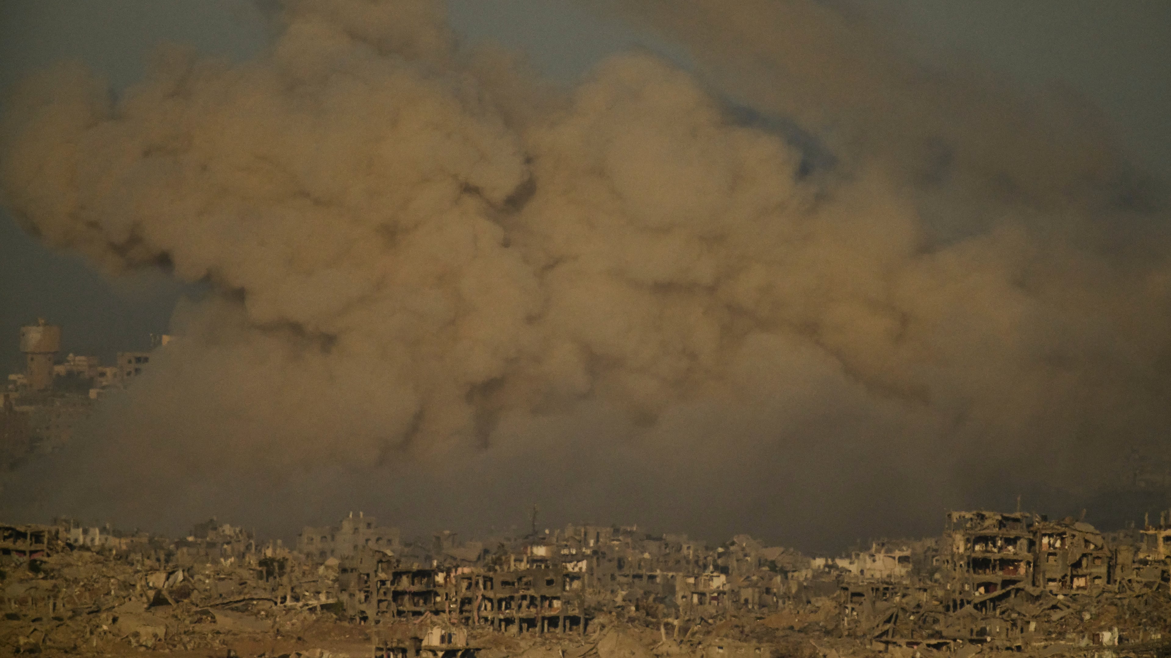 Buildings that were destroyed during the Israeli ground and air operations are engulfed by smoke following an Israeli military strike in the northern Gaza Strip, as seen from southern Israel, Saturday, Sept. 20, 2025. (AP Photo/Leo Correa)