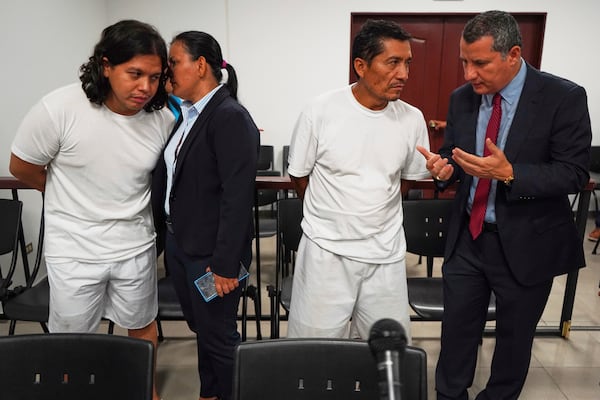 Alejandro Henriquez, left, and Jose Angel Perez, second from right, speak with their lawyers prior to their first court hearing in Santa Tecla, El Salvador, Friday, May 30, 2025. The National Civil Police arrested them for protesting near the presidential residence. (AP Photo/Salvador Melendez)