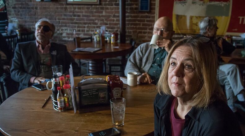 Helen Schroeder sits with her friends and watches Donald J. Trump’s inauguration on one of the many televisions at Manuel’s Tavern on Friday. STEVE SCHAEFER / SPECIAL TO THE AJC