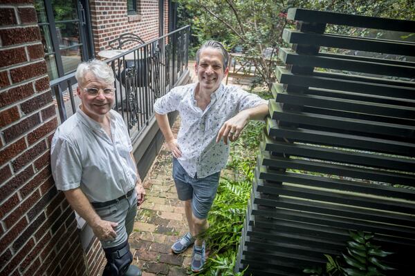 Matthew Hallett, left and his husband Daniel Smith stand in the side patio of their home, Wednesday, July 10, 2024, in Savannah, Ga. Hallett and Smith installed six-foot deep trenches on three sides of the house and filled them with tons of gravel to create French drains to mitigate flooding in their neighborhood. (AJC Photo/Stephen B. Morton)