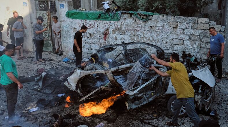 EDS NOTE: GRAPHIC CONTENT - Palestinians try to extinguish a burning car after an Israeli military strike in Gaza City, Sunday, Aug. 2, 2026. (AP Photo/Jehad Alshrafi)