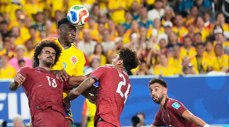 Colombia's Jhon Lucumi (3) leaps above Portugal's Renato Veiga (13) and Samu Costa (24) to head the ball during the World Cup Group K soccer match between Colombia and Portugal in Miami Gardens, Fla., Saturday, June 27, 2026. (AP Photo/Rebecca Blackwell)