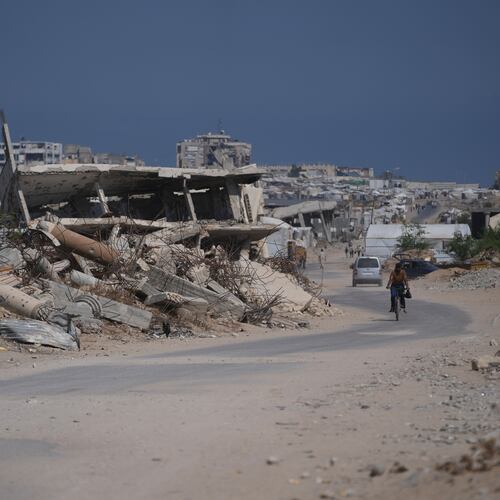 A Palestinian man rides his bicycle by the rubble of buildings that were destroyed during the Israel Hamas war, in Khan Younis, southern Gaza Strip, Friday, July 31, 2026. (AP Photo/Abdel Kareem Hana)