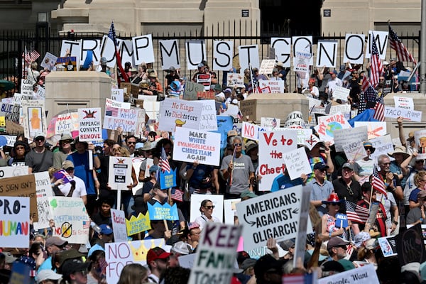 Demonstrators hold signs outside of the Capitol in Atlanta during a "No Kings" protest against Trump administration policies last Saturday.