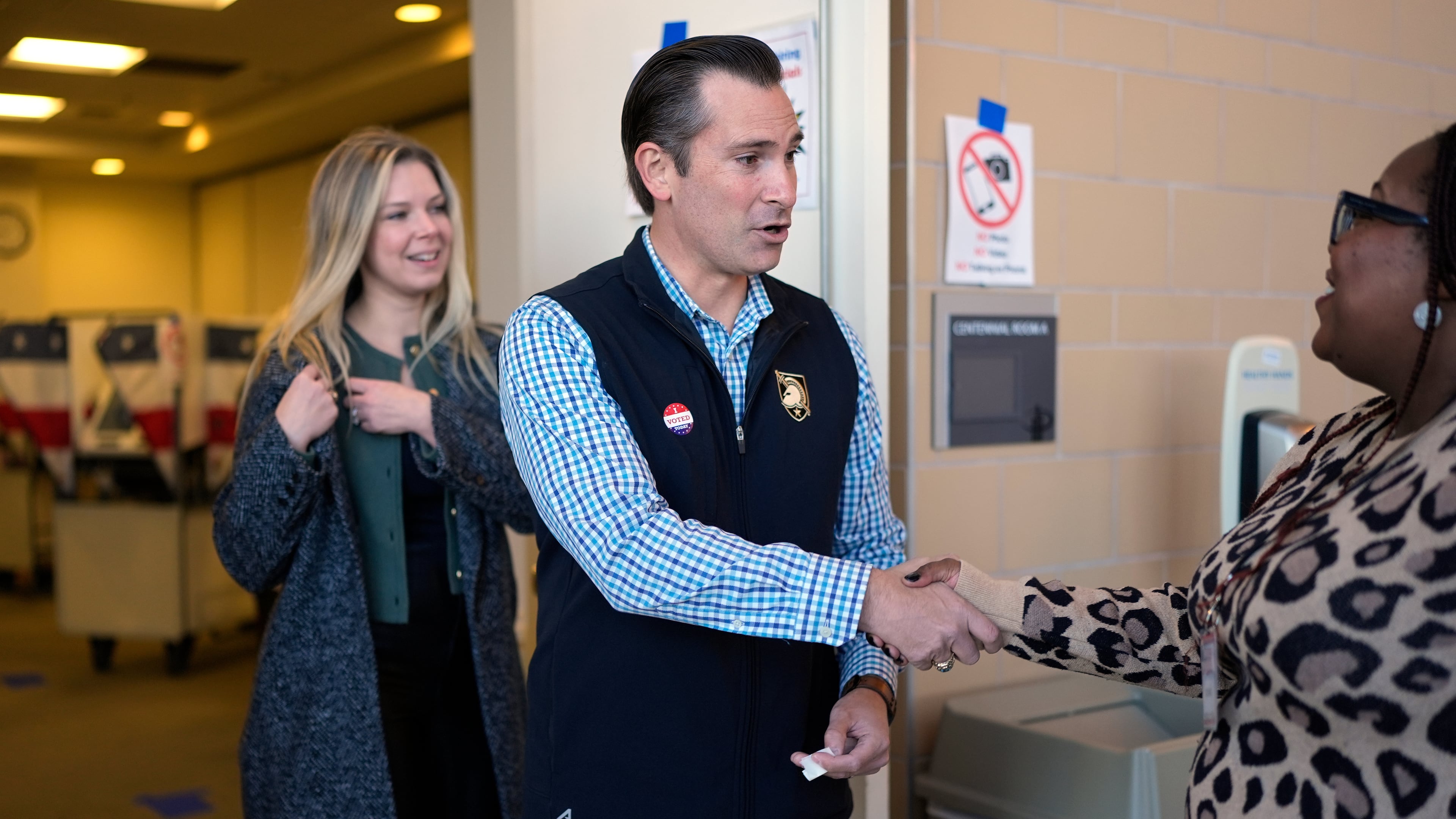 Republican congressional candidate Matt Van Epps, center, and his wife Meg Wrather, left, greet a poll worker after casting their ballots at an early voting site in the special election for the seventh district, Wednesday, Nov. 12, 2025, in Nashville, Tenn. (AP Photo/George Walker IV)