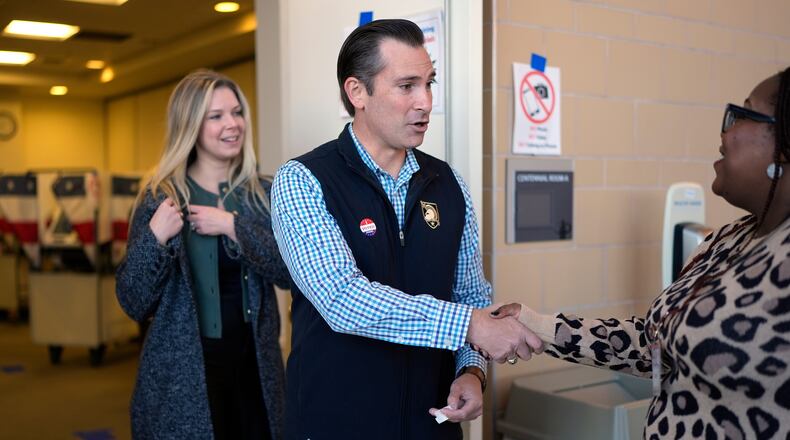 Republican congressional candidate Matt Van Epps, center, and his wife Meg Wrather, left, greet a poll worker after casting their ballots at an early voting site in the special election for the seventh district, Wednesday, Nov. 12, 2025, in Nashville, Tenn. (AP Photo/George Walker IV)