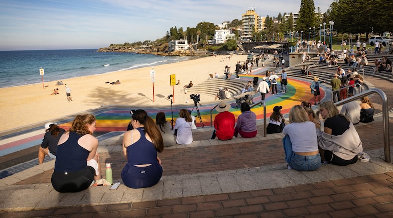People sit on stairs at Coogee beach following a shark attack in Sydney, Saturday, June 13, 2026. (Nadir Kinani/AAP Image via AP)