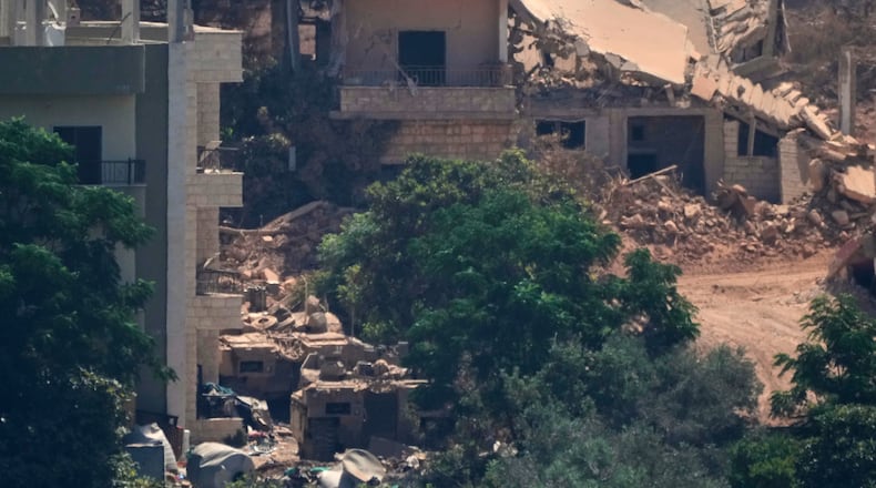 Israeli military vehicles, left, are seen stationed among homes in the village of Zawtar al-Sharqiyah, occupied by Israeli forces, is seen from the southern village of Zawtar al-Gharbieh, Lebanon, Wednesday, Aug. 5, 2026. (AP Photo/Mohammed Zaatari)