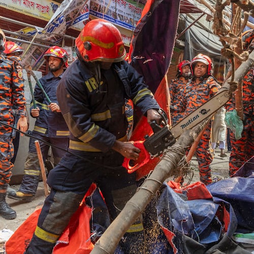 Rescue and fire officials cut building railings falling on the street to make way after an earthquake in Dhaka, Bangladesh, Friday, Nov. 21, 2025. (AP Photo/Abdul Goni)