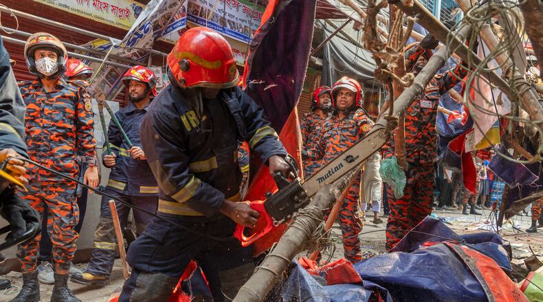 Rescue and fire officials cut building railings falling on the street to make way after an earthquake in Dhaka, Bangladesh, Friday, Nov. 21, 2025. (AP Photo/Abdul Goni)