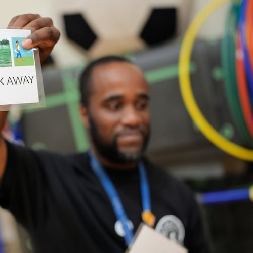 Health and physical education teacher Ronald Anderson holds instructions for students when they encounter a firearm during a gun safety lesson at Berclari Elementary School, Monday, Oct. 27, 2025, in Memphis, Tenn. (AP Photo/George Walker IV)