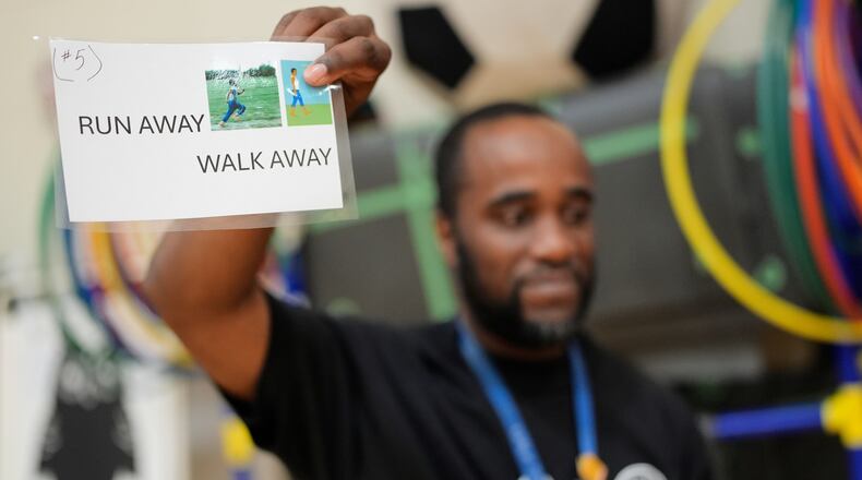 Health and physical education teacher Ronald Anderson holds instructions for students when they encounter a firearm during a gun safety lesson at Berclari Elementary School, Monday, Oct. 27, 2025, in Memphis, Tenn. (AP Photo/George Walker IV)