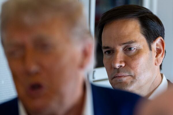 Secretary of State Marco Rubio stands behind as President Donald Trump speaks with reporters on Air Force One while in flight from Joint Base Andrews, Md., to Amsterdam, Netherlands, Tuesday, June 24, 2025. (AP Photo/Alex Brandon)