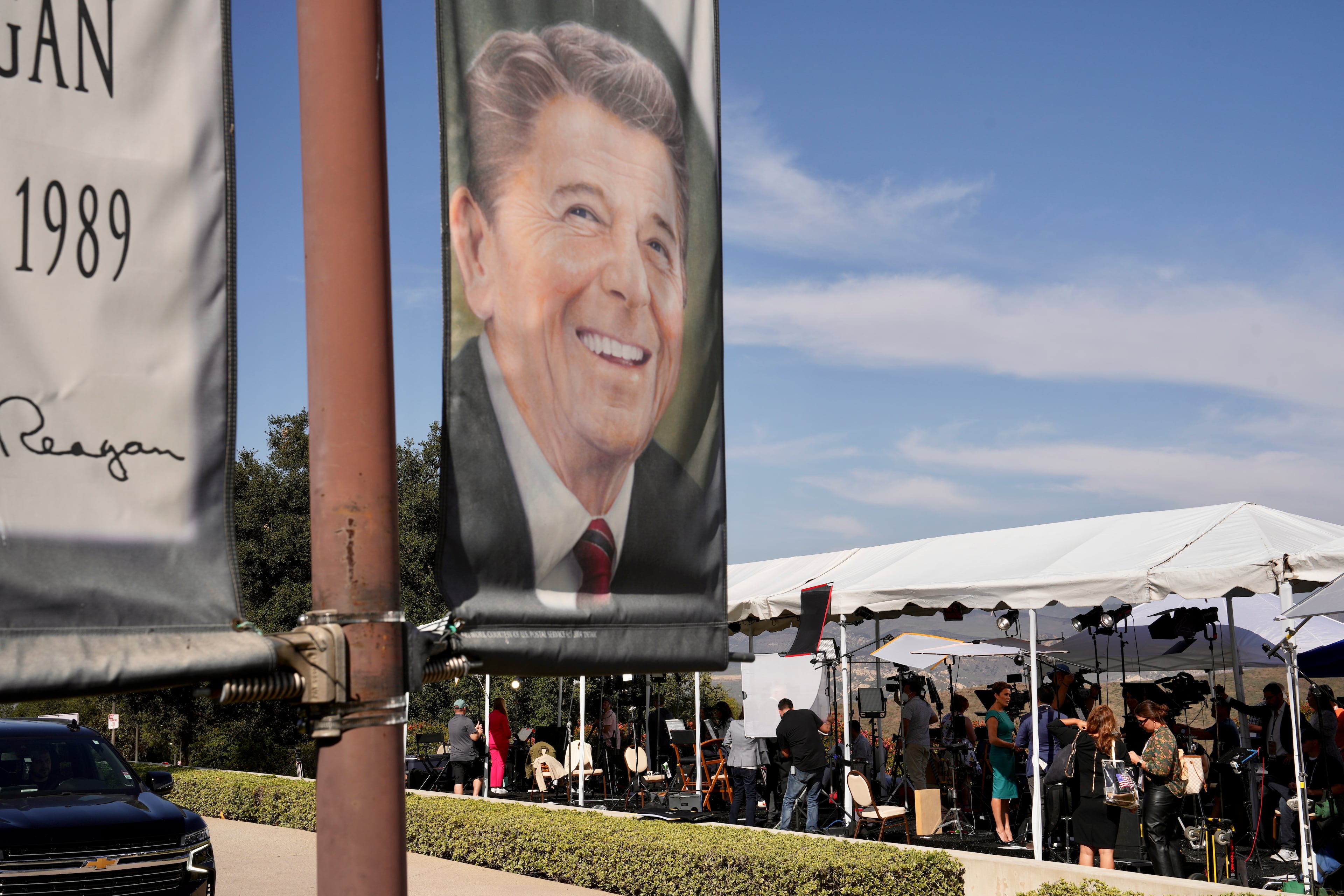 A banner of former President Ronald Reagan as reporters work under a tent ahead of the second Republican presidential debate at the Reagan Library in Simi Valley, Calif., Sept. 27, 2023. (Todd Heisler/New York Times)