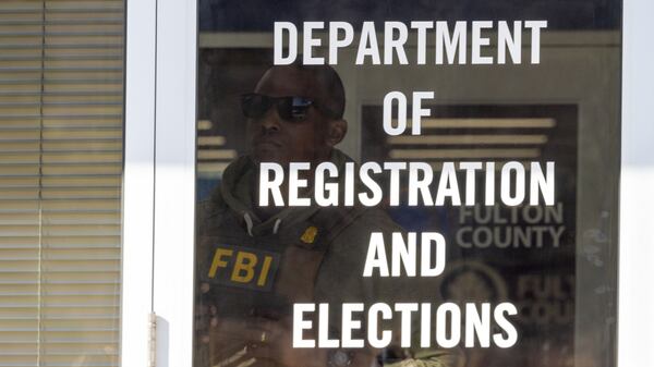 An FBI agent looks outside a window from the Fulton County Election Hub and Operation Center in Union City on Wednesday, Jan. 28, 2026, as the FBI conducts a raid. (Arvin Temkar/AJC)