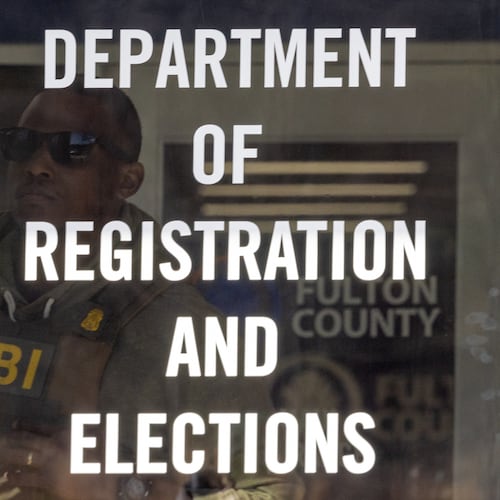 An FBI agent looks outside a window from the Fulton County Election Hub and Operation Center in Union City on Wednesday, Jan. 28, 2026, as the FBI conducts a raid. (Arvin Temkar/AJC)