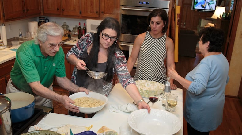 Charlie Augello (left) and his daughter Andrea Faye ready the fresh Cavatelli noodles as his other daughter Claudia Smith and his wife Anita Augello (right) looks on before a big family dinner Sunday in their Sandy Springs home June 4, 2017. STEVE SCHAEFER / SPECIAL TO THE AJC
