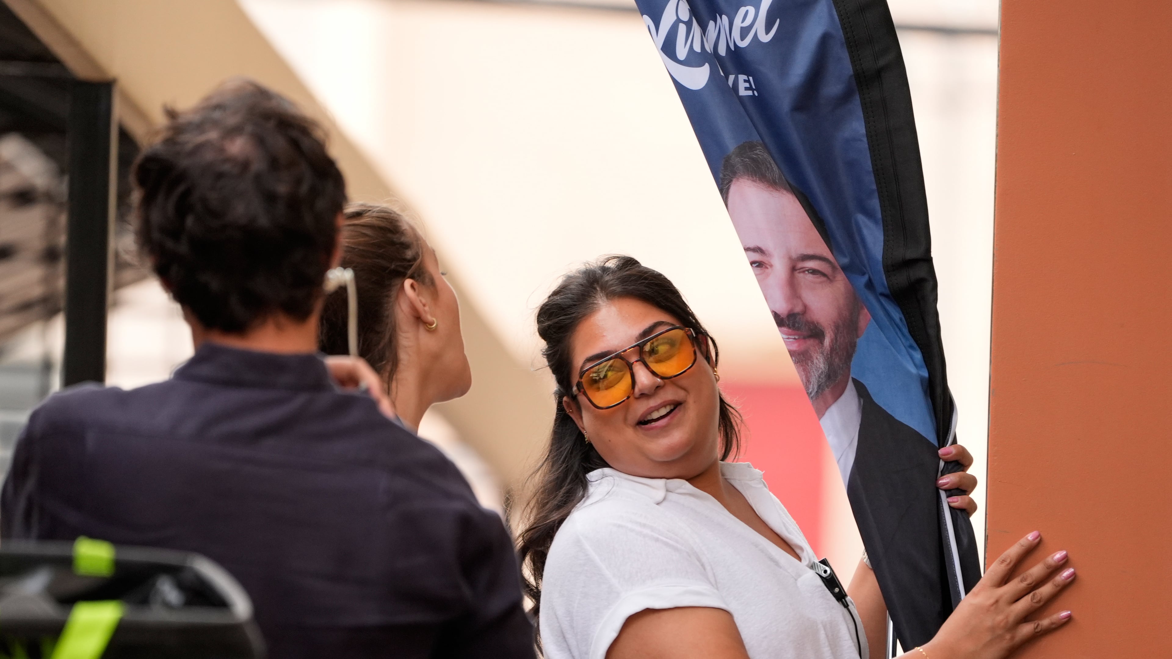 A "Jimmy Kimmel Live!" crew member brings in a banner sporting his likeness before a taping of the show at the show's studio on Hollywood Blvd., on Tuesday, Sept. 23, 2025, in Los Angeles. (AP Photo/Chris Pizzello)