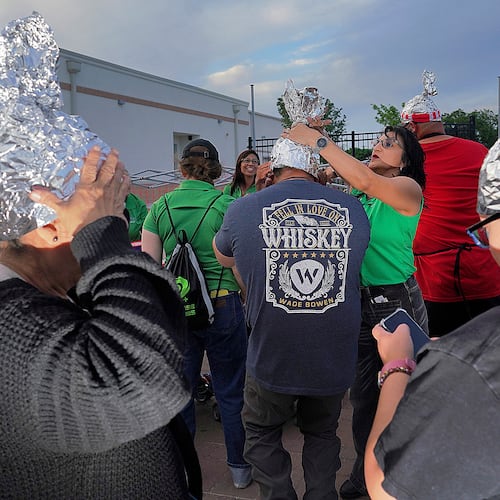 FILE - Attendees playfully wear tin foil hats at the Edinburg UFO Festival, April 5, 2024, in Edinburg, Texas. (Joel Martinez/The Monitor via AP, File)