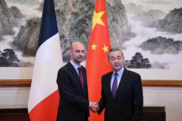 French Foreign Minister Jean-Noel Barrot, left, is greeted by China's Foreign Minister Wang Yi at the Diaoyutai State Guesthouse in Beijing Thursday, March 27, 2025. (Greg Baker/Pool Photo via AP)