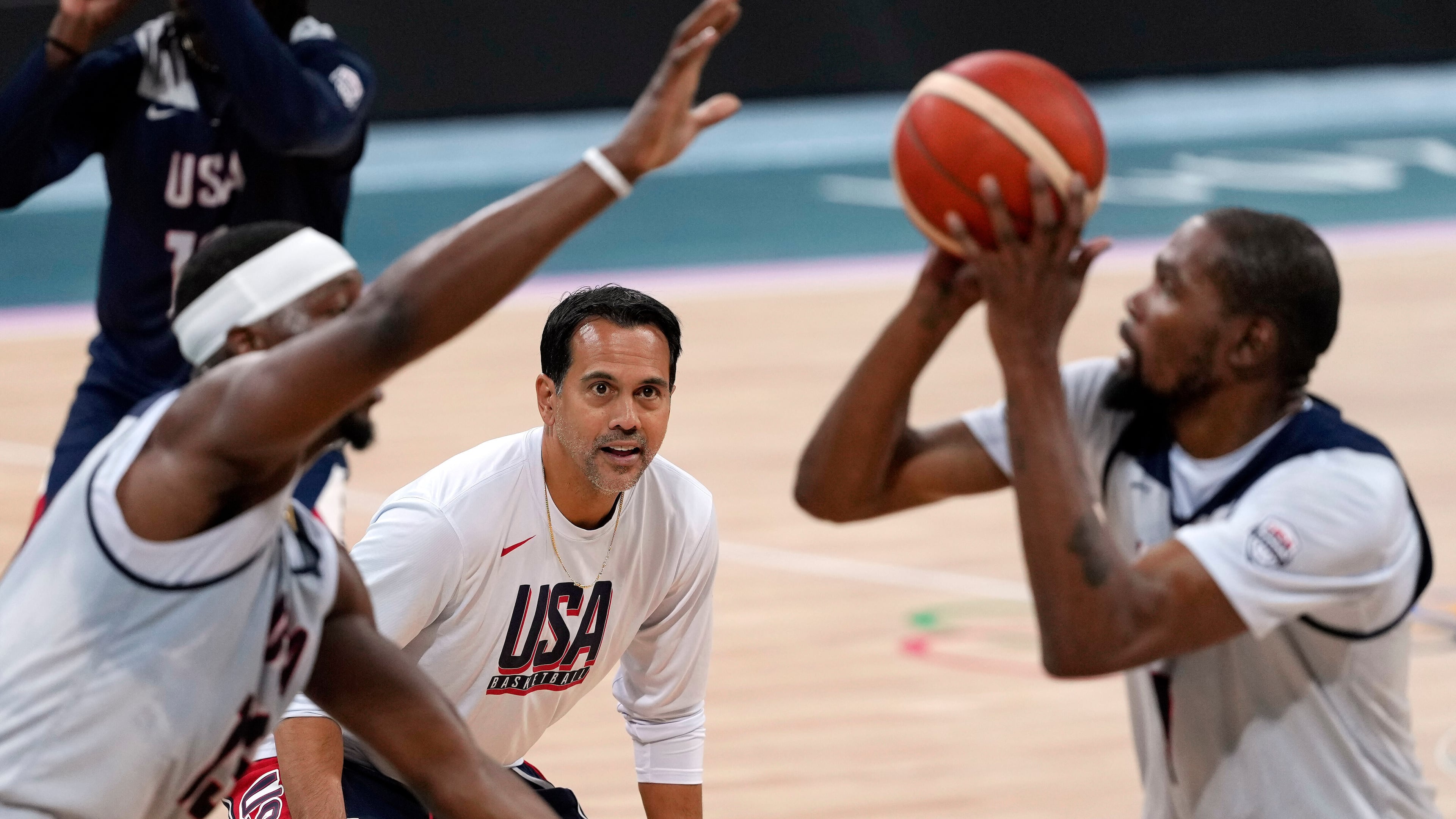 FILE - United State's Kevin Durant, right, shoots as Bam Adebayo, left, defends while assistant coach Erik Spoelstra watches during men's basketball practice at the 2024 Summer Olympics, Wednesday, July 24, 2024, in Villeneuve-d'Ascq, France. (AP Photo/Mark J. Terrill, File)