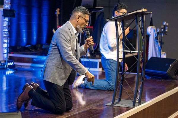 José Luis Orozco, a pastor from Nicaragua, kneels on stage as he ministers to members of the Oasis Church, in Taylor, Texas, June 15, 2025. (AP Photo/Rodolfo Gonzalez)
