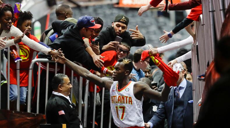 Atlanta Hawks guard Dennis Schroder is mobbed by fans as he leaves the court following their 102-99 win over the San Antonio Spurs in an NBA basketball game Monday, Jan. 15, 2018, in Atlanta. (AP Photo/John Bazemore)