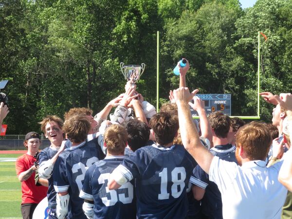 Members of the Marist War Eagles boys lacrosse team celebrate upon receiving the GHSA Division I championship trophy Saturday, May 17, 2025, at Denmark High in Alpharetta. The War Eagles defeated the Allatoona Buccaneers 11-5 for their first championship in program history.